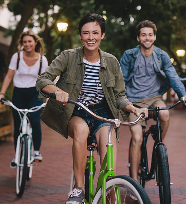 Trois amis faisant du vélo en ville