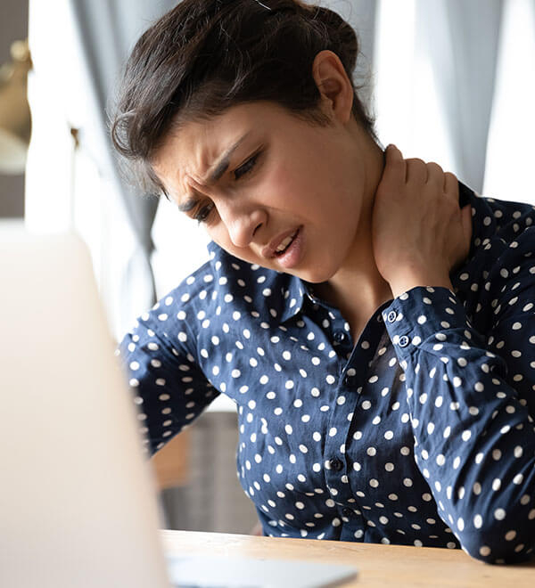 Jeune femme ayant mal au cou à son bureau