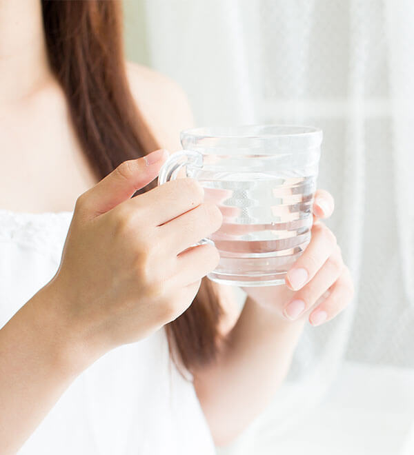 Close up of a woman holding a glass of water