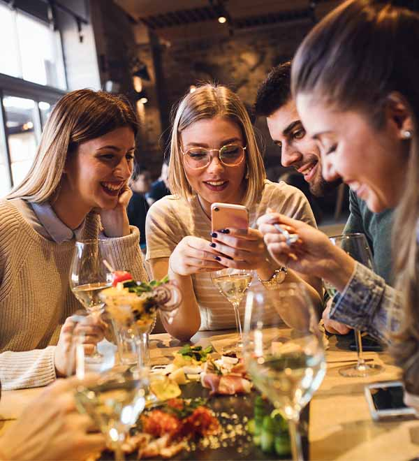 Een groep jonge mensen samen aan het eten in een restaurant
