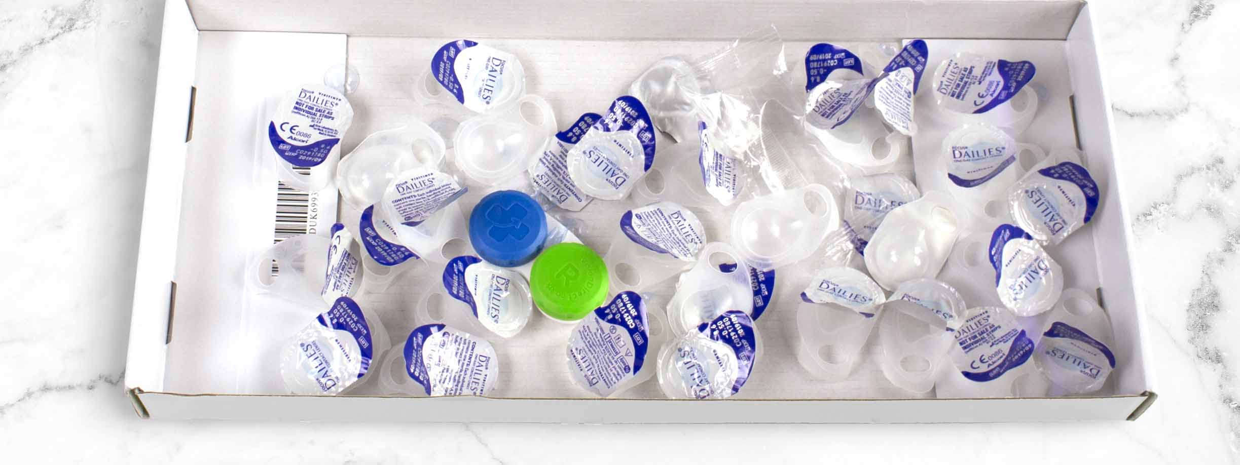 Een doos met lege contactlensverpakkingen 


