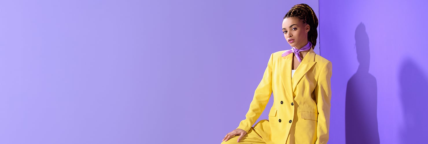 Femme portant un costume jaune et une bannière écharpe violette