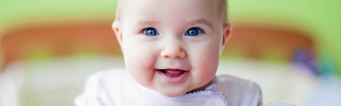 Een baby met bruine ogen kijkt omhoog

