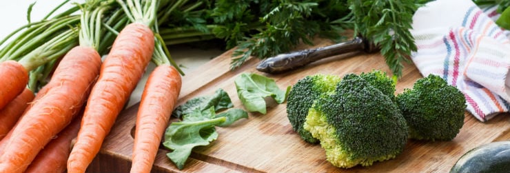 Een snijplank met broccoli en wortels