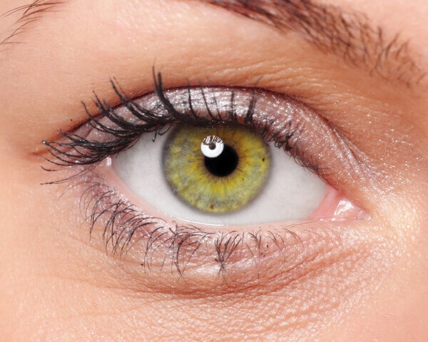occhio femminile con lente a contatto colorata verde chiaro