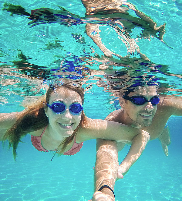 Een man en een vrouw aan het zwemmen met een zwembril