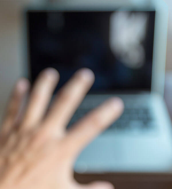 Een wazig beeld van een hand en een laptop