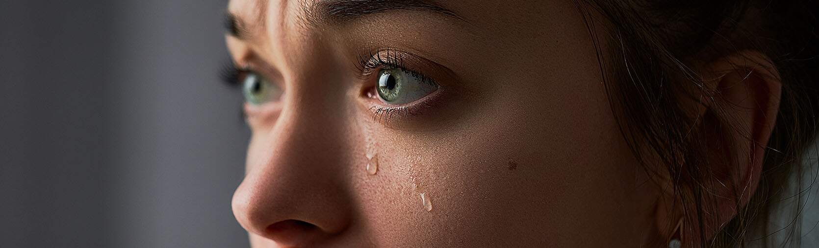 Een huilende vrouw met tranen op haar wangen