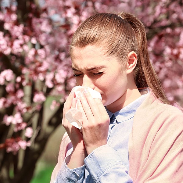 Mujer sufriendo los síntomas de la alergia en los ojos
